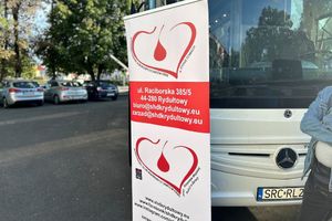 Na zdjęciu widać baner stowarzyszenia HDK ustawiony przed autobusem.