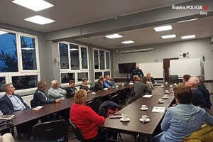 Na zdjęciu widać policjantów i mieszkańców w pomieszczeniu, podczas jednej z odbytych debat.