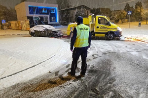 Na zdjęciu widać policjanta w rejonie ronda, a w tle lawetę i ciemny samochód.