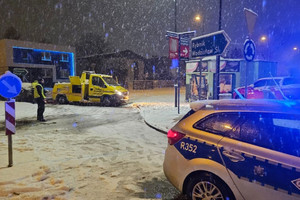 Na zdjęciu widać radiowóz, a w tle miejsce zdarzenia drogowego.