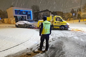 Na zdjęciu widać policjanta, uszkodzony samochód i autolawetę.