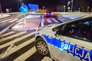 Na zdjęciu widać ciemny samochód w rejonie ronda oraz radiowóz blokujący drogę.