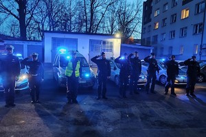 Na zdjęciu widać policjantów oddających hołd na parkingu żorskiej komendy.