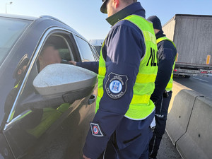 Na zdjęciu widać policjantów podczas akcji badania trzeźwości na węźle autostrady A1. Widać kontrolowane samochody osobowe i ciężarowe.