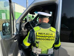 Na zdjęciu widać inspektora transportu drogowego podczas kontroli autobusu.