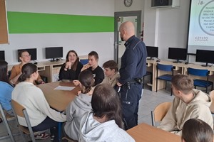 Na zdjęciu widać policjanta i uczniów podczas zajęć.