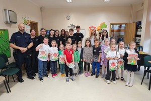 Na zdjęciu widać policjanta oraz uczestników konkursu na wspólnym zdjęciu.