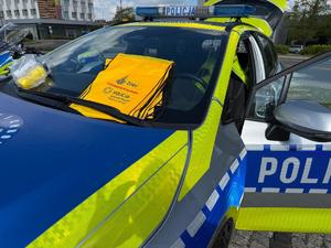 Na zdjęciu widać zbliżenie na maskę oraz przednią szybę radiowozu polskiej Policji. Na szybie, za wycieraczką znajdują się materiały promujące akcję &quot;Z trzeźwością mi po drodze&quot;.