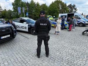 Na zdjęciu widać mężczyznę odwróconego plecami. Mężczyzna przebrany jest za amerykańskiego policjanta. W tle widać amerykańskie i polskie radiowozy oraz uczestników wydarzenia.