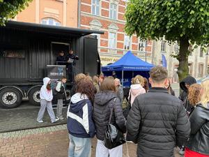 Na zdjęciu widać zgromadzonych uczniów i policjantów przed ciężarówką.