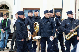 Na zdjęciu widać policjantów z orkiestry policyjnej stojących na płycie rynku.