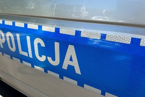 Na zdjęciu widać bok policyjnego radiowozu z napisem Policja.