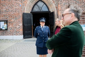 Na zdjęciu widać Panią Komendant, a w tle budynek kościoła.