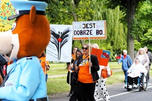 Na zdjęciu widać policyjną maskotkę oraz uczestników przemarszu.