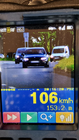 Na zdjęciu widać bmw podczas pomiaru prędkości przez urządzenie. widać wynik 106 km/h.