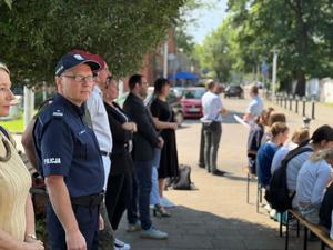 Na zdjęciu widać galerię murali podczas ich tworzenia, a także uczniów i zgromadzonych podczas akcji pod nazwą &quot;Plenerowa lekcja patriotyzmu&quot;.