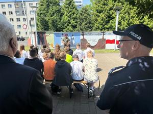 Na zdjęciu widać galerię murali podczas ich tworzenia, a także uczniów i zgromadzonych podczas akcji pod nazwą &quot;Plenerowa lekcja patriotyzmu&quot;.