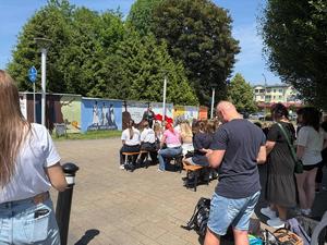 Na zdjęciu widać galerię murali podczas ich tworzenia, a także uczniów i zgromadzonych podczas akcji pod nazwą &quot;Plenerowa lekcja patriotyzmu&quot;.