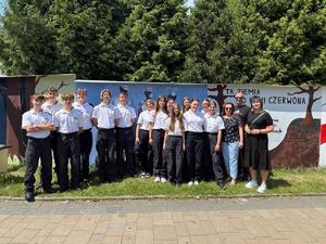 Na zdjęciu widać galerię murali podczas ich tworzenia, a także uczniów i zgromadzonych podczas akcji pod nazwą &quot;Plenerowa lekcja patriotyzmu&quot;.