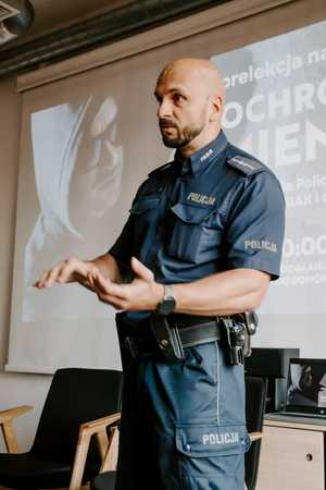 Na zdjęciu widać policjanta w trakcie spotkania z mieszkańcami.