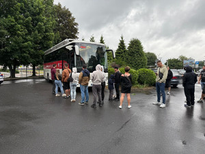 Na zdjęciu widać mobilny punkt krwiodawstwa - autobus oraz osoby oczekujące w kolejce.