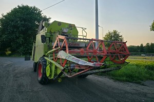 Na zdjęciu widać zielony kombajn.