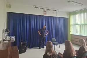 Na zdjęciu widać uczniów i policjanta podczas spotkania profilaktycznego.