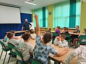 Na zdjęciu widać policjanta oraz dzieci podczas spotkania.
