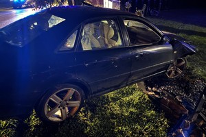 Na zdjęciu widać uszkodzony ciemny samochód.