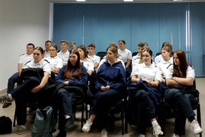 Na zdjęciu widać policjanta, prelegentów oraz uczestników debaty w zgromadzonych w sali odpraw żorskiej komendy Policji.