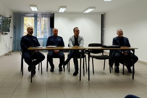 Na zdjęciu widać policjanta, prelegentów oraz uczestników debaty w zgromadzonych w sali odpraw żorskiej komendy Policji.
