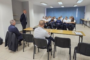 Na zdjęciu widać policjanta, prelegentów oraz uczestników debaty w zgromadzonych w sali odpraw żorskiej komendy Policji.