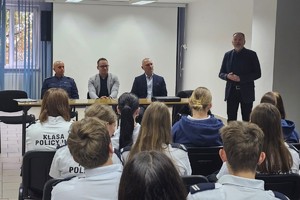 Na zdjęciu widać policjanta, prelegentów oraz uczestników debaty w zgromadzonych w sali odpraw żorskiej komendy Policji.