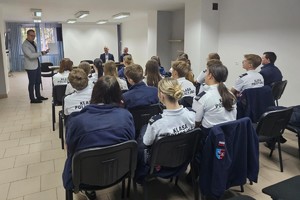 Na zdjęciu widać policjanta, prelegentów oraz uczestników debaty w zgromadzonych w sali odpraw żorskiej komendy Policji.