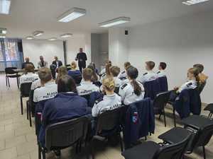 Na zdjęciu widać policjanta, prelegentów oraz uczestników debaty w zgromadzonych w sali odpraw żorskiej komendy Policji.