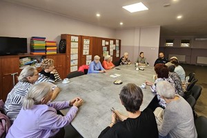 Na zdjęciu widać policjanta oraz uczestników spotkania.