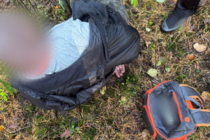 Na zdjęciu widać zatrzymanego mężczyznę oraz plecak.