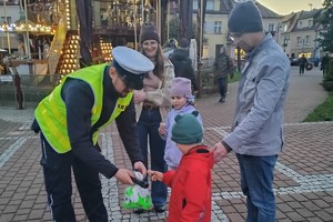 Na zdjęciu widać policjanta oraz uczestników czytania na żorskim Rynku.