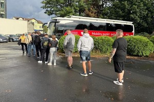 Na zdjęciu widać autobus krwiodawstwa oraz osoby oczekujące na rejestrację.