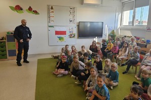 Na zdjęciu widać przedszkolaków oraz policjanta podczas spotkania.