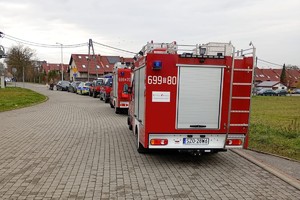 Na zdjęciu widać zaparkowane samochody służb ratunkowych.