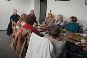 Na zdjęciu widać policjanta oraz osoby zgromadzone podczas spotkania.