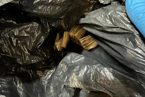 Na zdjęciu widać czarny worek z pieniędzmi w środku.