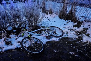 Na zdjęciu widać radiowóz, ciąg pieszo-rowerowy, rower oraz zabudowania.