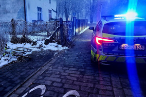 Na zdjęciu widać radiowóz, ciąg pieszo-rowerowy, rower oraz zabudowania.