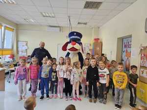 Na zdjęciu widać policjanta, dzieci i Sznupka.