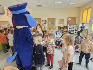 Na zdjęciu widać policjanta, dzieci i Sznupka.