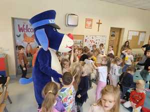 Na zdjęciu widać policjanta, dzieci i Sznupka.