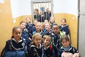 Na zdjęciu widać policjanta oraz zuchy podczas wizyty w żorskiej komendzie Policji.