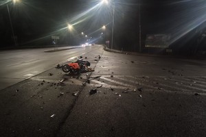 Na zdjęciu widać uszkodzony motocykl, drogę i przejeżdżające pojazdy.